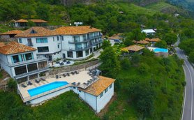 Ein malerisches Resort mit mehreren Gebäuden, umgeben von üppigem Grün und einem einladenden Poolbereich.