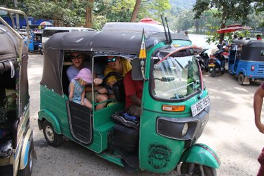 Familie sitzt gemeinsam in einem grünen Tuk-Tuk in Kandy – Sri Lanka Familienreise