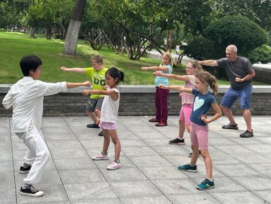 Eltern und Kinder üben gemeinsam Schattenboxen im Park von Xi’an – China Reise mit Kindern