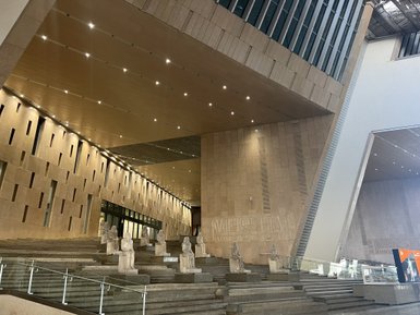 Eine moderne Eingangshalle mit sanften Lichtakzenten und beeindruckenden Statuen, die eine eindrucksvolle Atmosphäre schaffen.