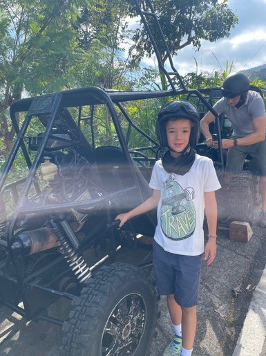 Kind steht neben einem Quad-Buggy während einer Tour auf Bali – Bali Familienreise