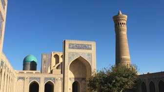 Der Po-i-Kalyan-Komplex in Buchara zeigt beeindruckende Architektur mit einem hohen Minarett und einer blauen Kuppel.