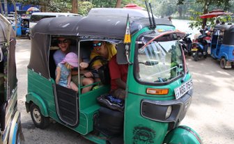 Familie sitzt gemeinsam in einem grünen Tuk-Tuk in Kandy – Sri Lanka Familienreise