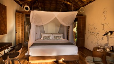 Ein stilvolles Zimmer mit einem großen Bett, umgeben von hellen Wänden und einem kunstvollen Wandgemälde eines Radfahrers.