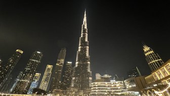 Der Burj Khalifa erhebt sich majestätisch über die Skyline von Dubai, umgeben von glitzernden Wolkenkratzern und einem ruhigen Wasser.