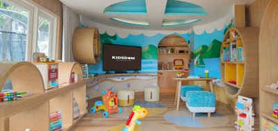 Ein farbenfroher Spielraum für Kinder mit Spielzeug, einem Fernseher und einer einladenden, kreativen Atmosphäre.