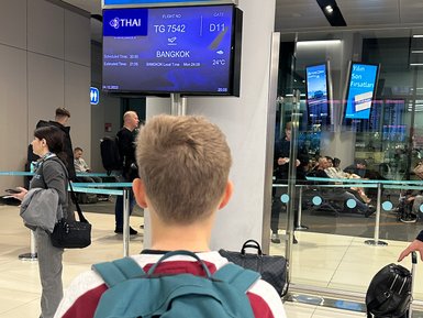 Teenager wartet am Gate auf seinen Abflug nach Bangkok – Thailand Reise mit Kindern