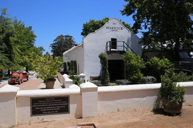 Eingangstor des Weinguts Warwick mit gepflegtem Garten – Garden Route mit Kindern