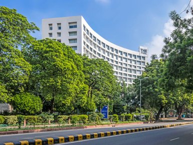 Das moderne Hotel 'The Park' erhebt sich elegant zwischen üppigem Grün und strahlend blauem Himmel in Neu-Delhi.