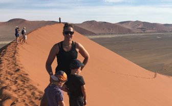 Eine Mutter steht mit zwei Kindern auf einer Sanddüne - Namibia Rundreise mit Kindern