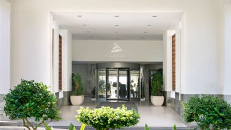 Der Eingangsbereich des Atlantica Miramare Beach Hotels mit modernen Pflanzen und einem beeindruckenden Holzdach.