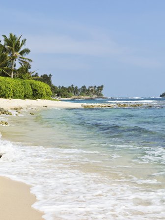 Glasklares Wasser schimmert in der Sonne an einem ruhigen Strand – Sri Lanka Reise mit Kindern