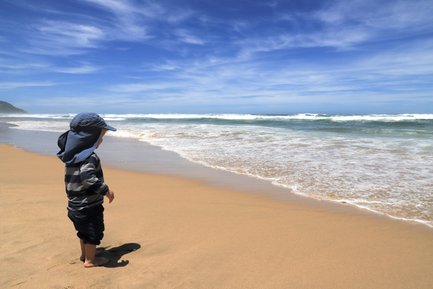 Kind steht an der Küste und blickt aufs Meer – Garden Route mit Kindern