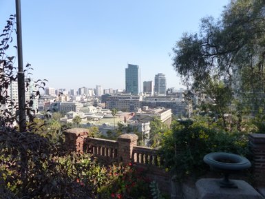 Ein Blick auf die Stadt Santiago mit modernen Hochhäusern und historischen Gebäuden unter einem klaren blauen Himmel.