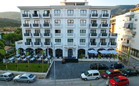 Das elegante Hotel Chimaera mit weißer Fassade und Balkonen bietet eine einladende Atmosphäre in einer malerischen Umgebung.
