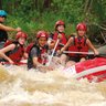 Gemeinsam paddelnde Gruppe im roten Rafting-Boot – Costa Rica Reise mit Kindern