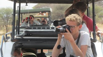 Familie macht Fotos von der Tierwelt aus dem Safarijeep – Tansania Reise mit Kindern
