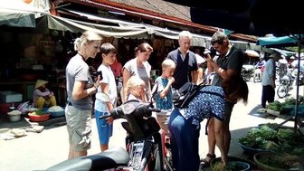 Familie schlendert über einen traditionellen Markt in Hoi An – Vietnam Familienreise