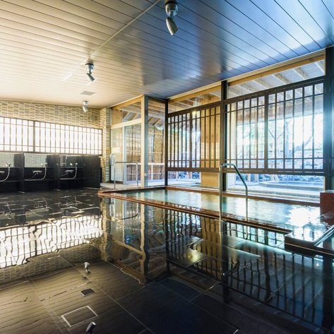 Ein elegantes Innenbad mit glänzendem Boden und großen Fenstern, die viel Tageslicht hereinlassen.