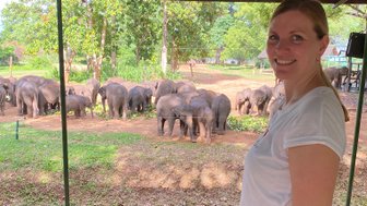 Frau steht vor dem Gehege mit Elefanten im Elephant Transit Home im Udawalawe Nationalpark – Sri Lanka mit Kindern