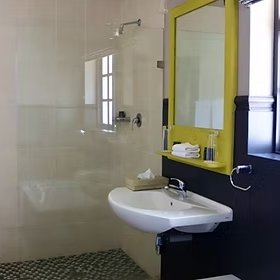 Ein modernes Badezimmer mit einem eleganten Waschbecken und einem großen Spiegel in einem hellen, minimalistischen Stil.