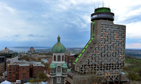 Die beeindruckende Architektur des Hotel Le Concorde in Quebec, umgeben von historischen Gebäuden und einer malerischen Landschaft.