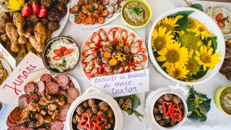 Ein reichhaltiges Buffet mit verschiedenen Fleischgerichten, frischen Salaten und bunten Beilagen, dekoriert mit Sonnenblumen.