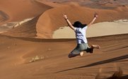 Kind springt mitten in den Dünen in der Wüste - Namibia Family & Teens - Namibia mit Teenagern
