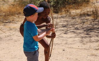 Ein Kind versucht einen Bogen zu spannen - Namibia Urlaub mit Kindern