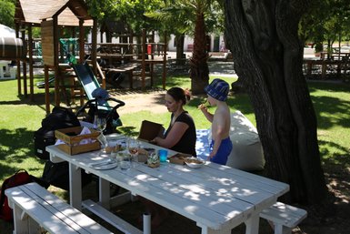 Mutter und Kind genießen ein Picknick eines idyllischen Weinguts in Stellenbosch – Garden Route Familienreise