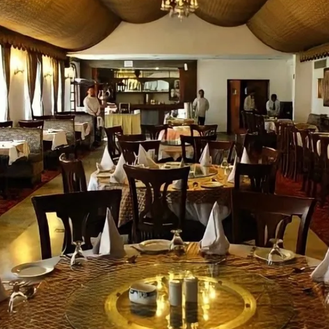 Ein elegantes Restaurant mit Holzmöbeln, schön gedeckten Tischen und einem warmen, einladenden Ambiente.