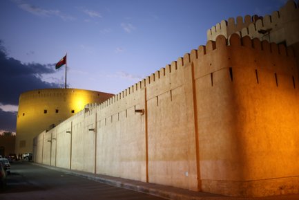 Festung von Nizwa beleuchtet bei Nacht im Oman – Oman Reise mit Kindern