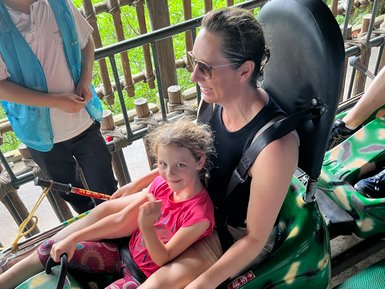Mutter und Kind genießen eine rasante Abfahrt beim Rodeln in Guilin – China mit Kindern