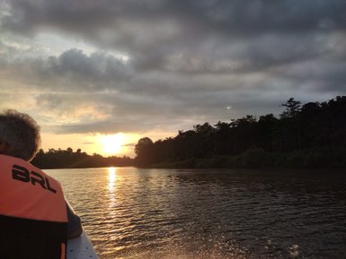 Orangener Abendhimmel über dem stillen Kinabatangan-Fluss – Malaysia & Borneo Reise mit Kindern