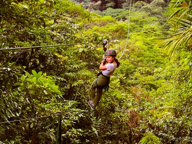 Ein mutiges Mädchen gleitet an einer Zipline durch die Baumwipfel des Regenwaldes – Costa Rica Familienreise