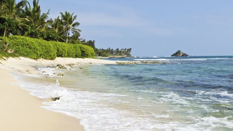 Glasklares Wasser schimmert in der Sonne an einem ruhigen Strand – Sri Lanka Reise mit Kindern