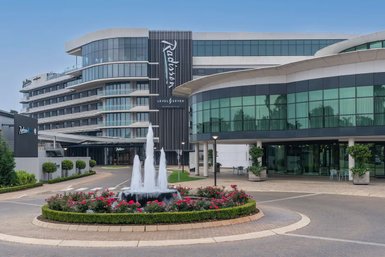 Das Radisson Hotel in Johannesburg zeigt eine moderne Architektur mit großen Fenstern und einem eleganten Eingangsbereich.
