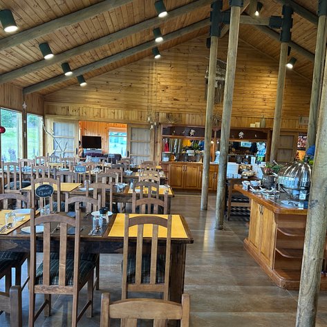 Der Essbereich eines gemütlichen Hotels mit Holztischen und Stühlen, die auf eine einladende Atmosphäre hinweisen.