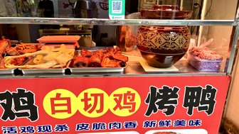 Ein Straßenstand bietet eine Vielzahl von Fleischgerichten, darunter gegrillte Hühnerteile und Meeresfrüchte, in einer lebhaften Umgebung.