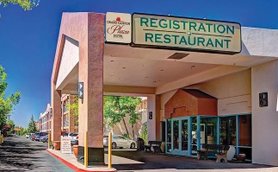 Der Eingangsbereich des Grand Canyon Plaza Hotels zeigt eine einladende Atmosphäre mit einem klaren blauen Himmel.