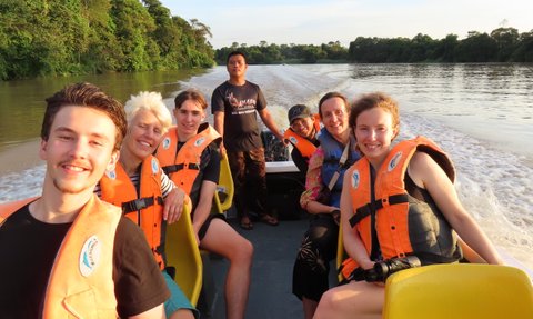 Familie posiert gemeinsam für ein Foto auf dem Boot während der Flusssafari am Kinabatangan – Malaysia & Borneo Familienreise