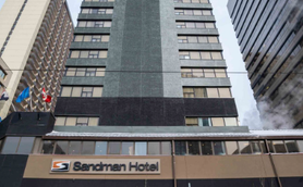 Das Sandman Hotel in Calgary erhebt sich majestätisch zwischen modernen Wolkenkratzern und bietet eine einladende Fassade.