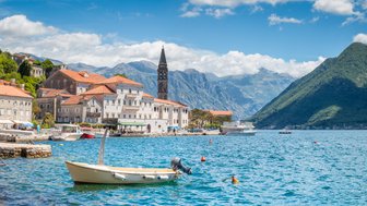 Die Hafenpromenade von Perast bei blauem Himmel