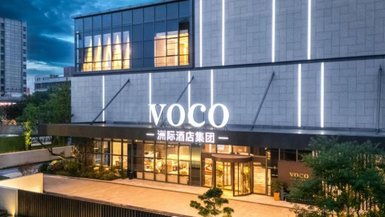 Das moderne Voco-Hotel in Chengdu strahlt Eleganz aus, mit einer stilvollen Fassade und einladenden Lichtern am Abend.
