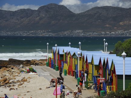 Farbenfrohe Strandhäuschen und badende Familien am St James Beach bei Kapstadt – Garden Route mit Kindern