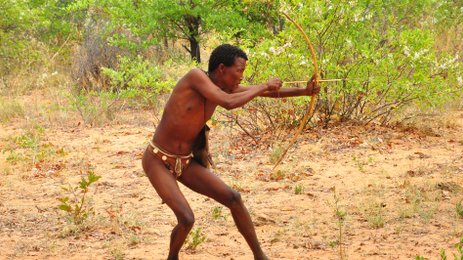 Ein Mann schießt mit einem kleinen Bogen - Namibia Urlaub mit Kindern