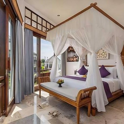 Ein elegantes Schlafzimmer mit einem Himmelbett, umgeben von weißen Vorhängen und bunten Kissen, strahlt Ruhe aus.