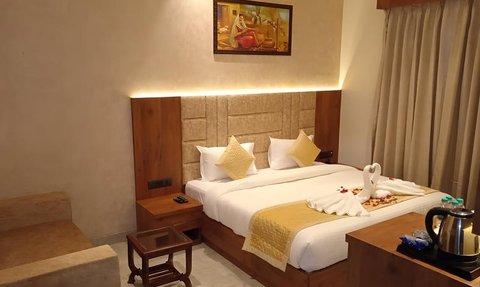 Ein elegantes Hotelzimmer mit einem großen Bett, dekoriert mit Kissen und einer kunstvollen Handtuchfigur in Form eines Schwans.
