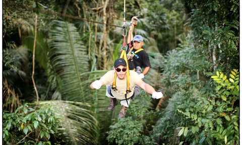 Teen fröhlich beim Ziplining durch den tropischen Wald – Mexiko Familienreise