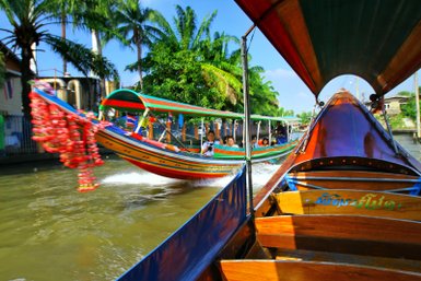 Traditionelles Longtail-Boot gleitet durch die Klongs von Thonburi – Thailand mit Kindern